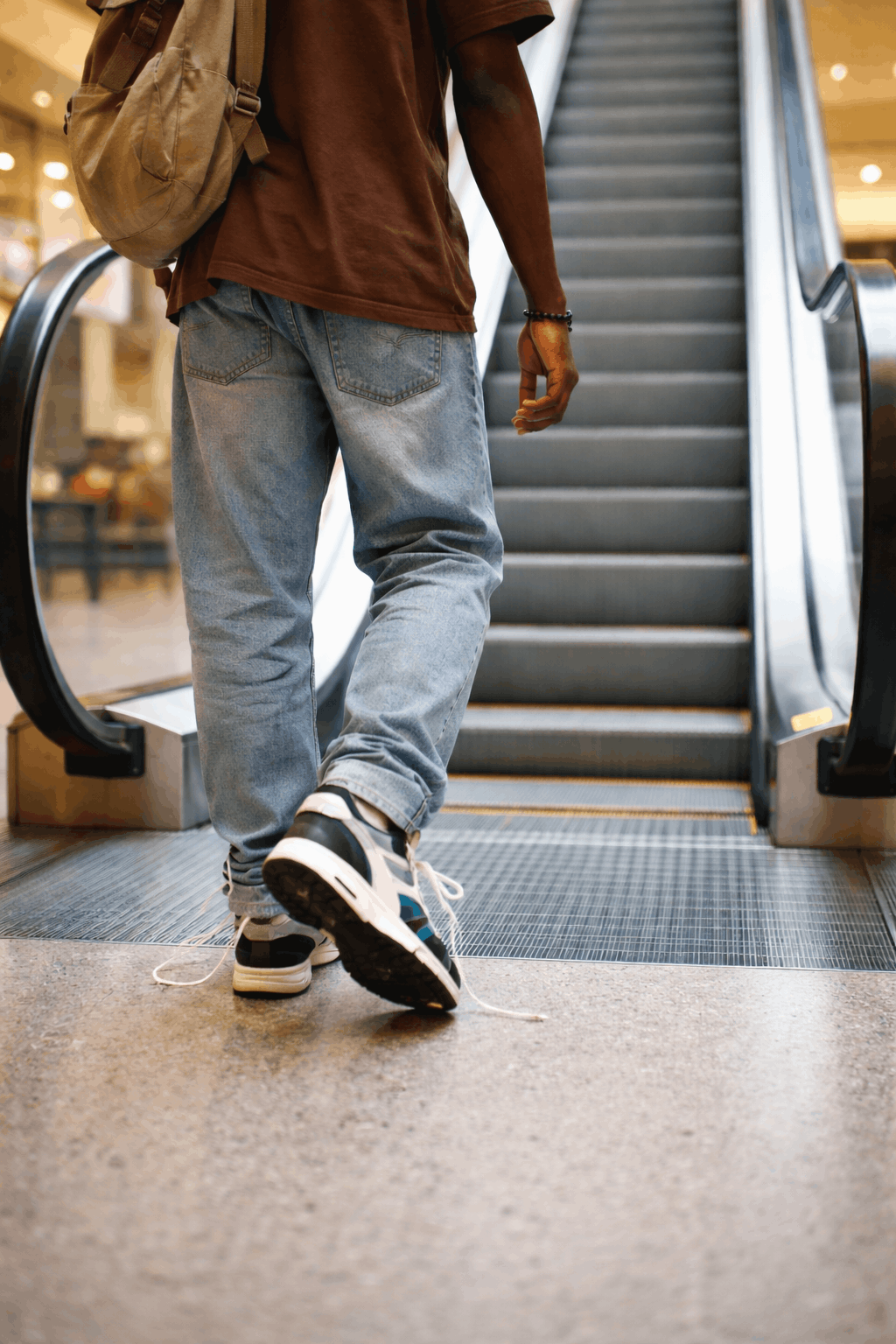 Improper footwear such as loose shoelaces on an escalator step creating a safety hazard
